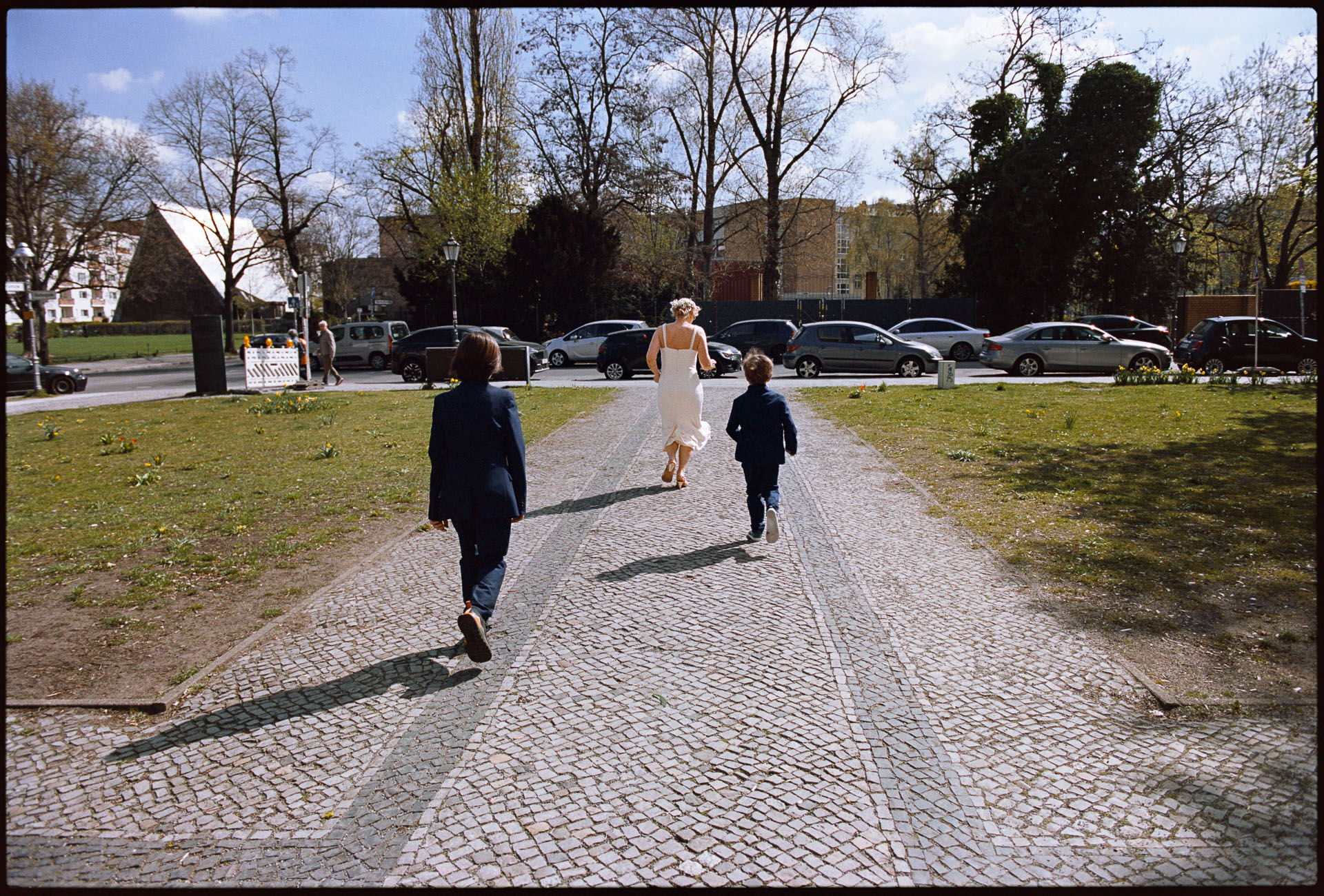 Children running ahead as the couple walk a path, Irena & Peter wedding in Berlin