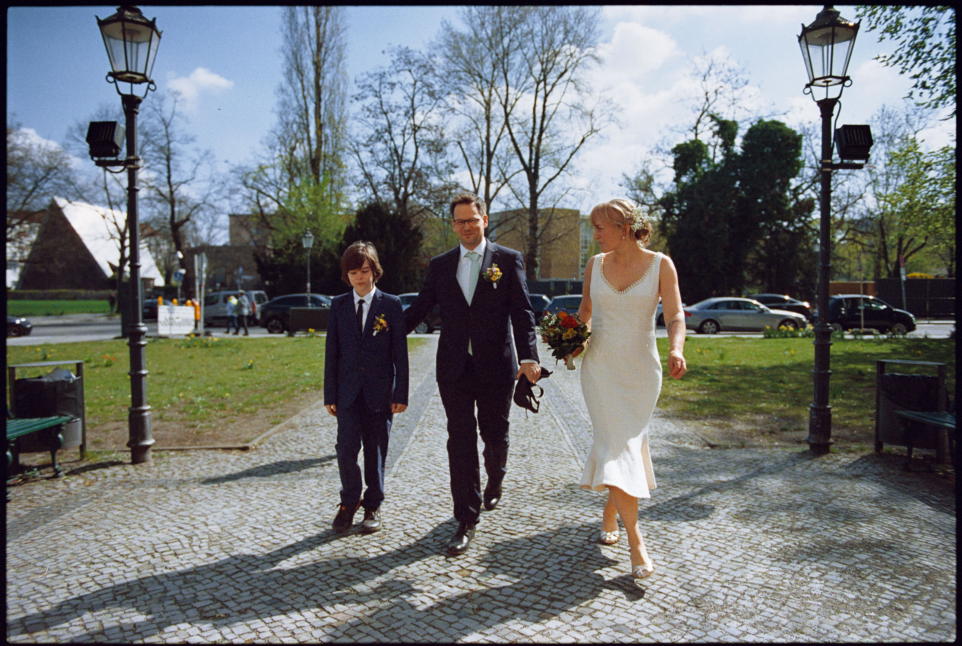The couple and a child walking across a square, Irena & Peter wedding in Berlin