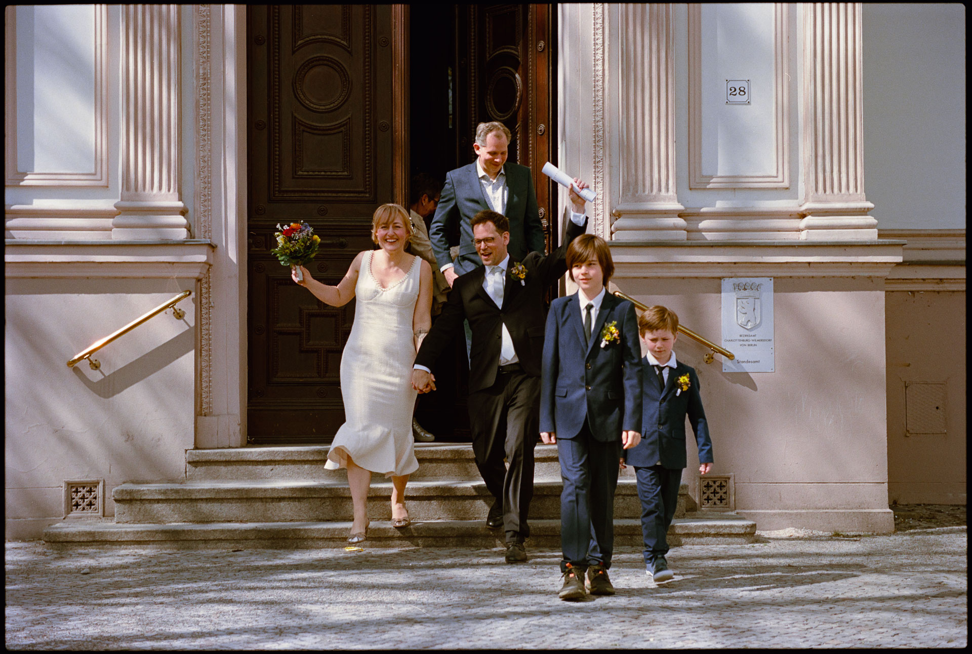 The couple leaving the registry office down the steps, Irena & Peter wedding in Berlin