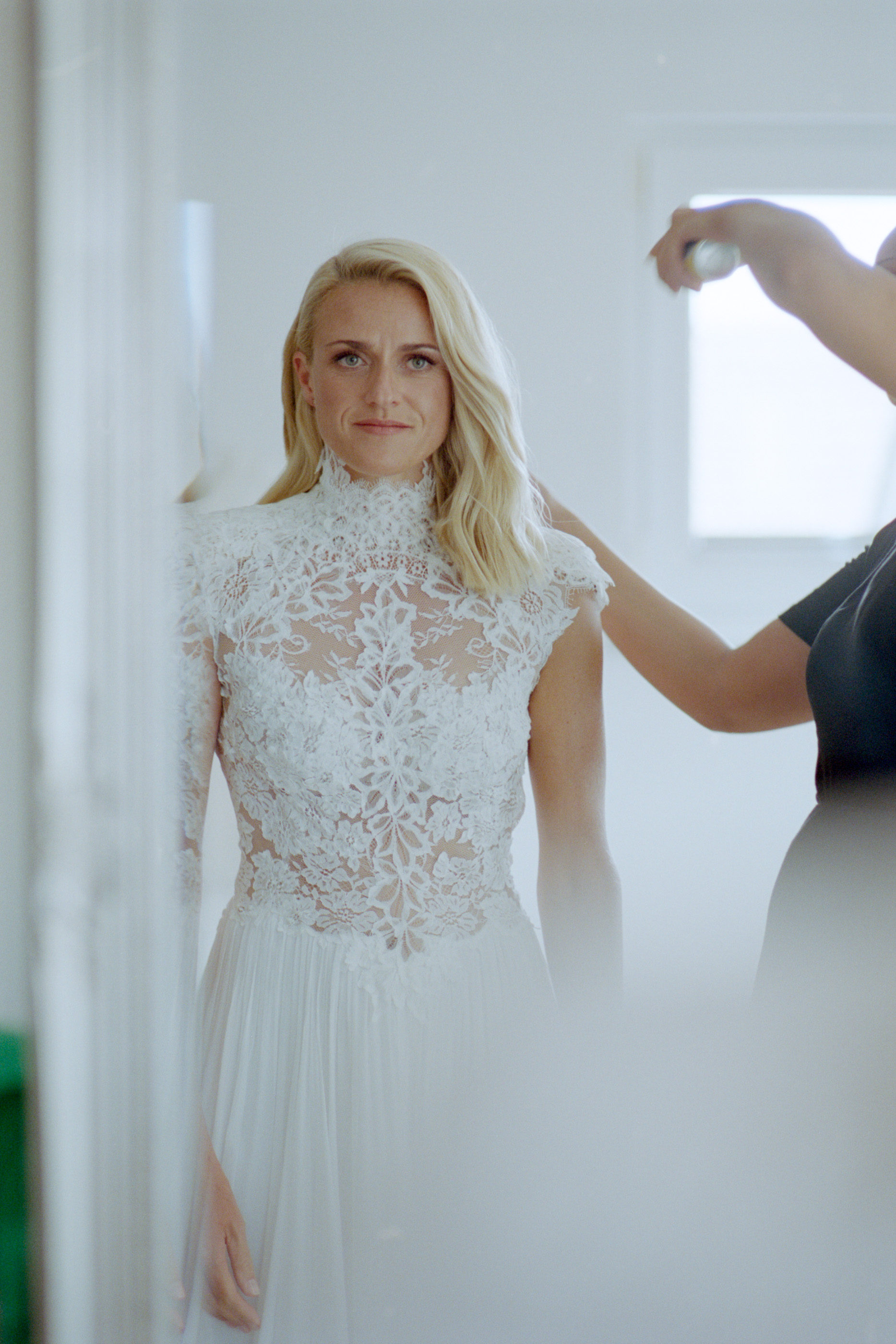 The bride by the window as her hair is finished, Linda & Thomas wedding in Berlin