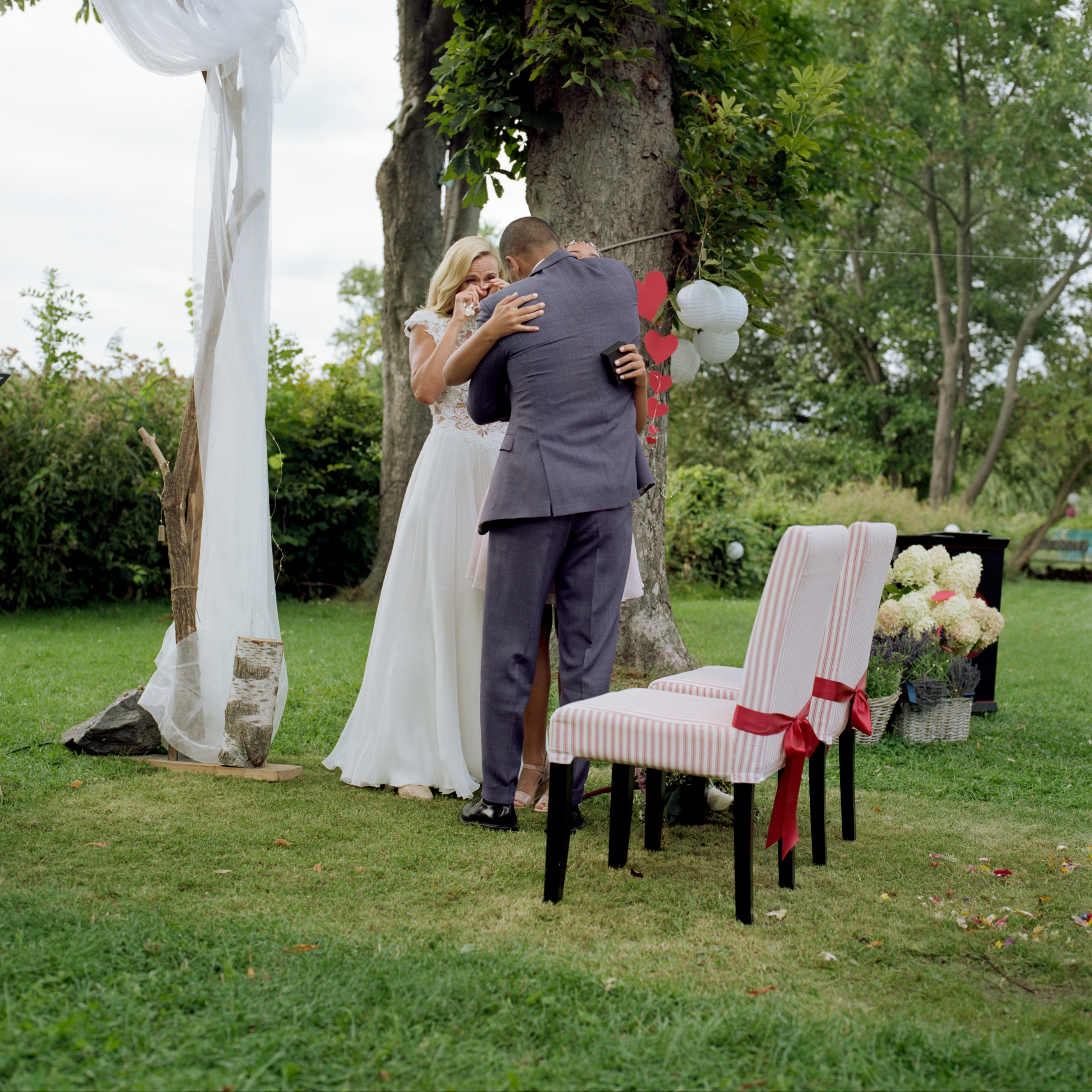 The couple embracing beneath a tree hung with ribbons, Linda & Thomas wedding in Berlin