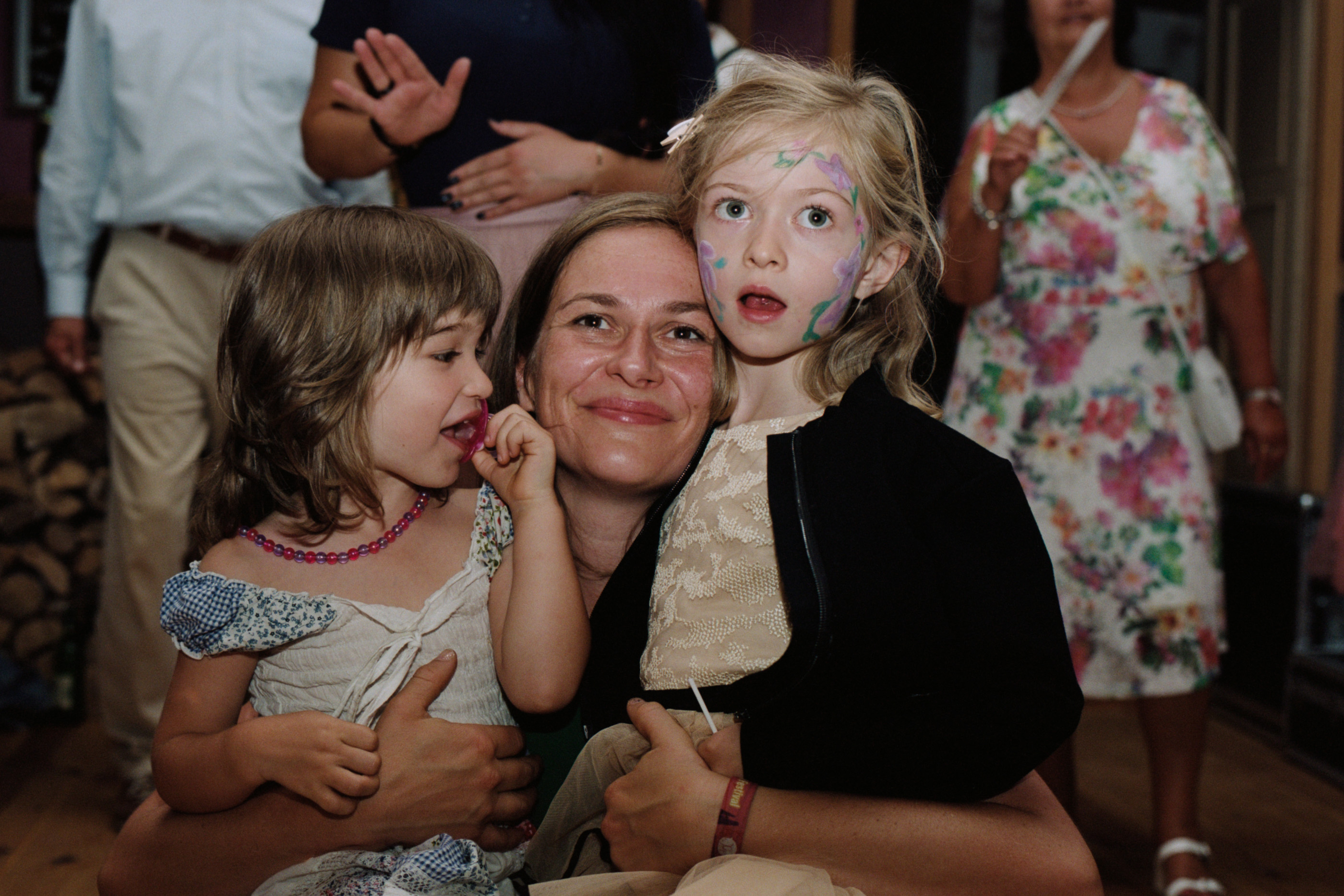 A guest holding two children with painted faces, Linda & Thomas wedding in Berlin