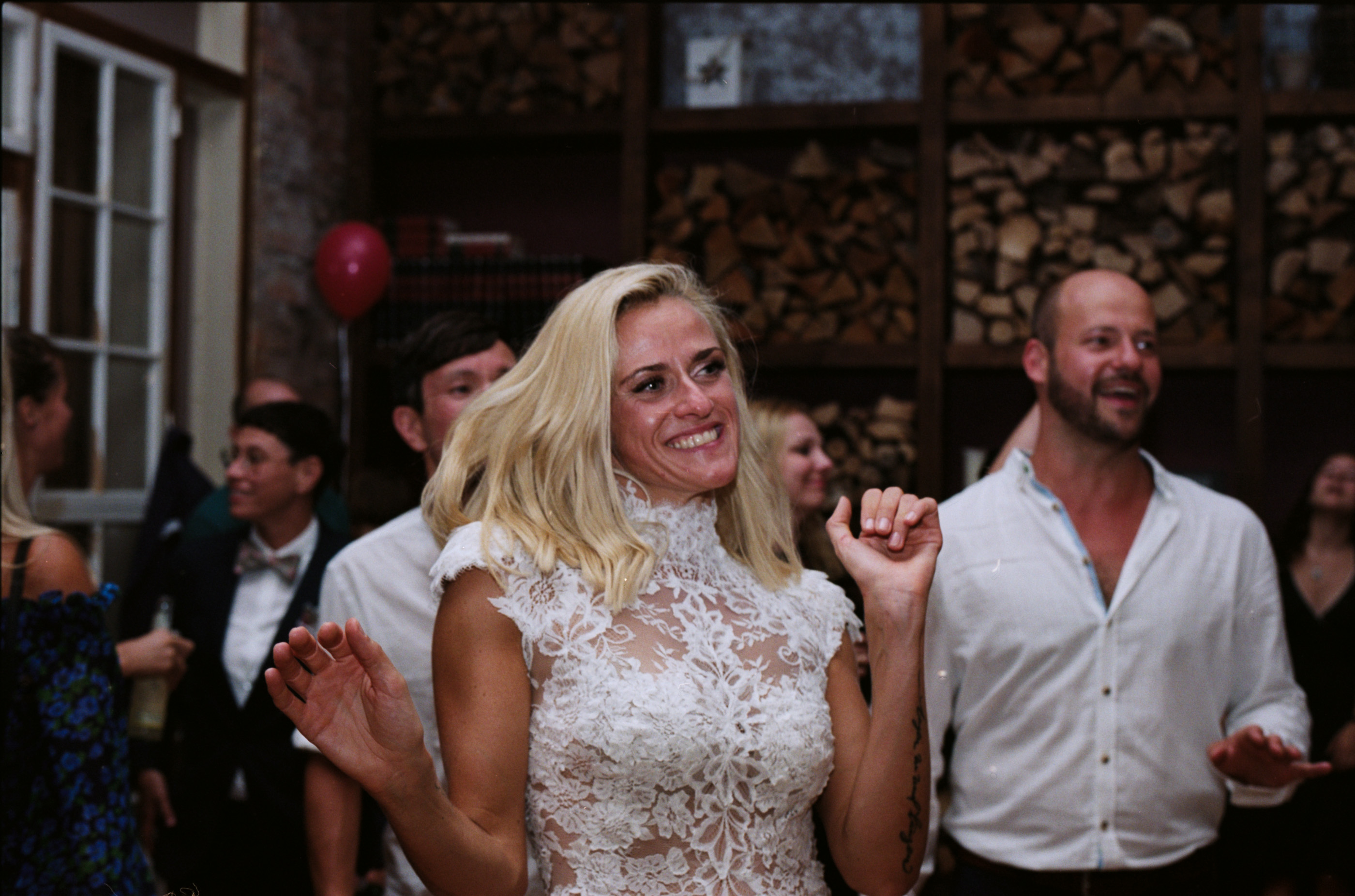 Guests dancing in a room lined with stacked firewood, Linda & Thomas wedding in Berlin