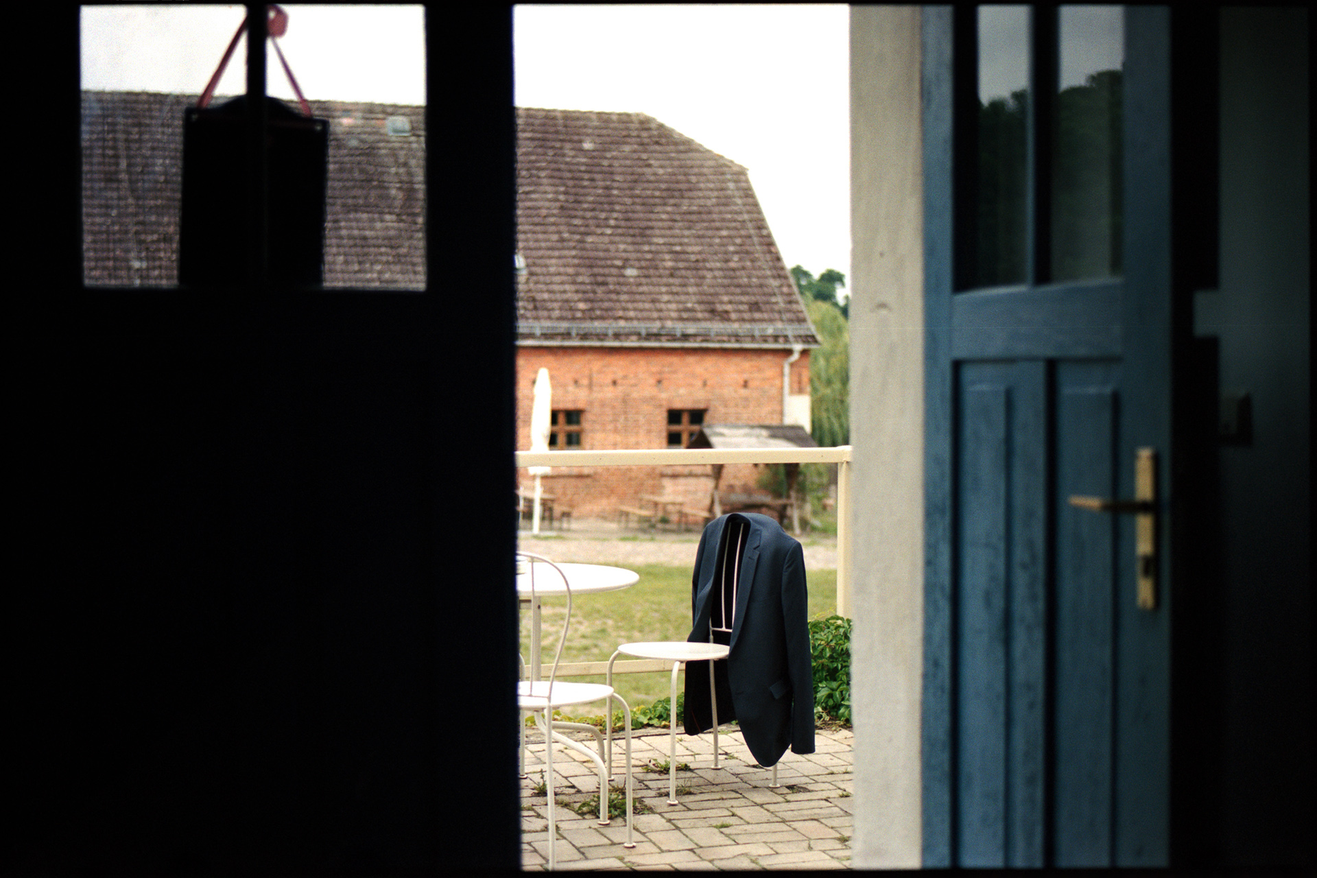 View through a doorway out to the farmyard, Maike & Daniel wedding in Brandenburg