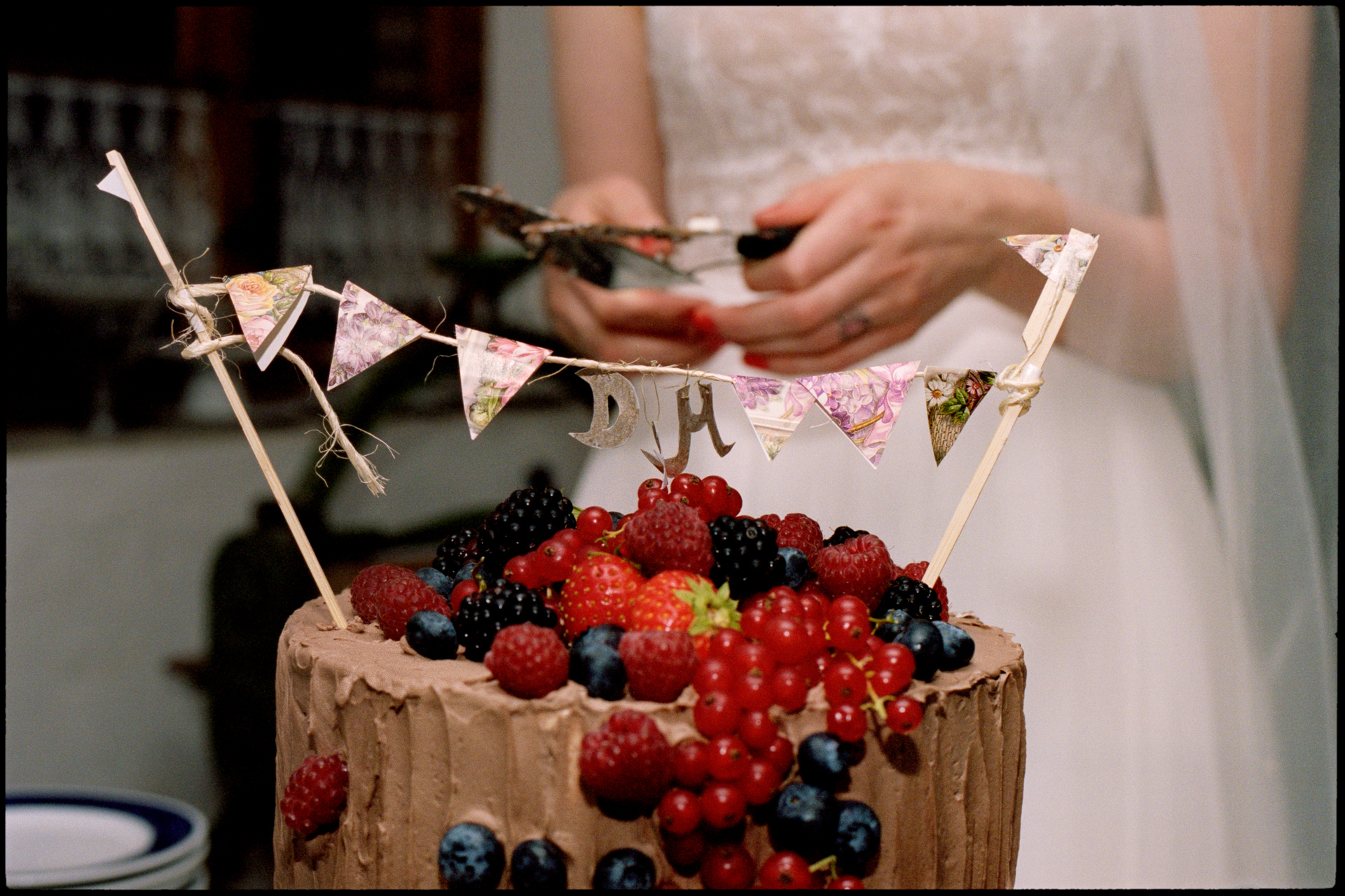 The berry-topped wedding cake with paper bunting, Maike & Daniel wedding in Brandenburg