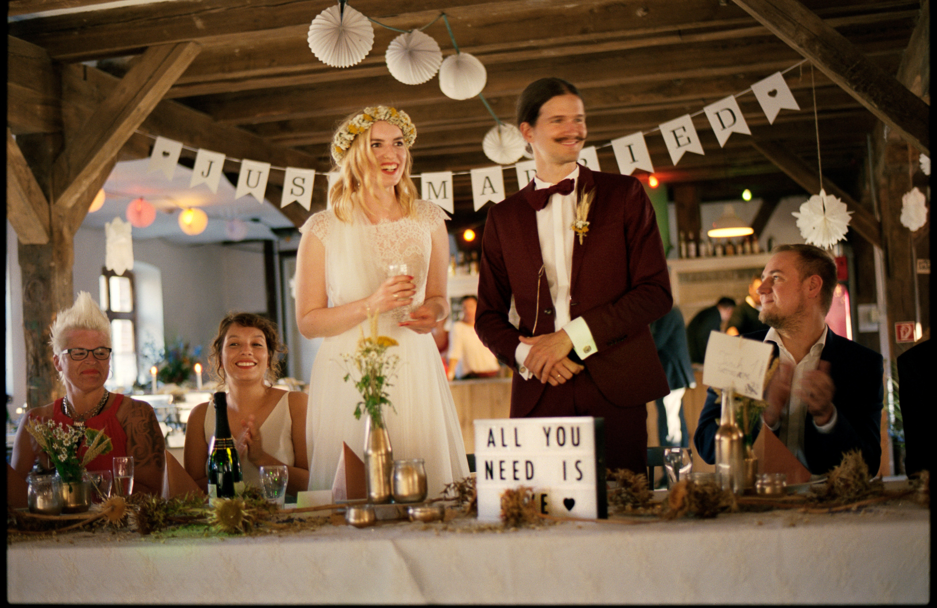 The couple at the reception under paper bunting, Maike & Daniel wedding in Brandenburg