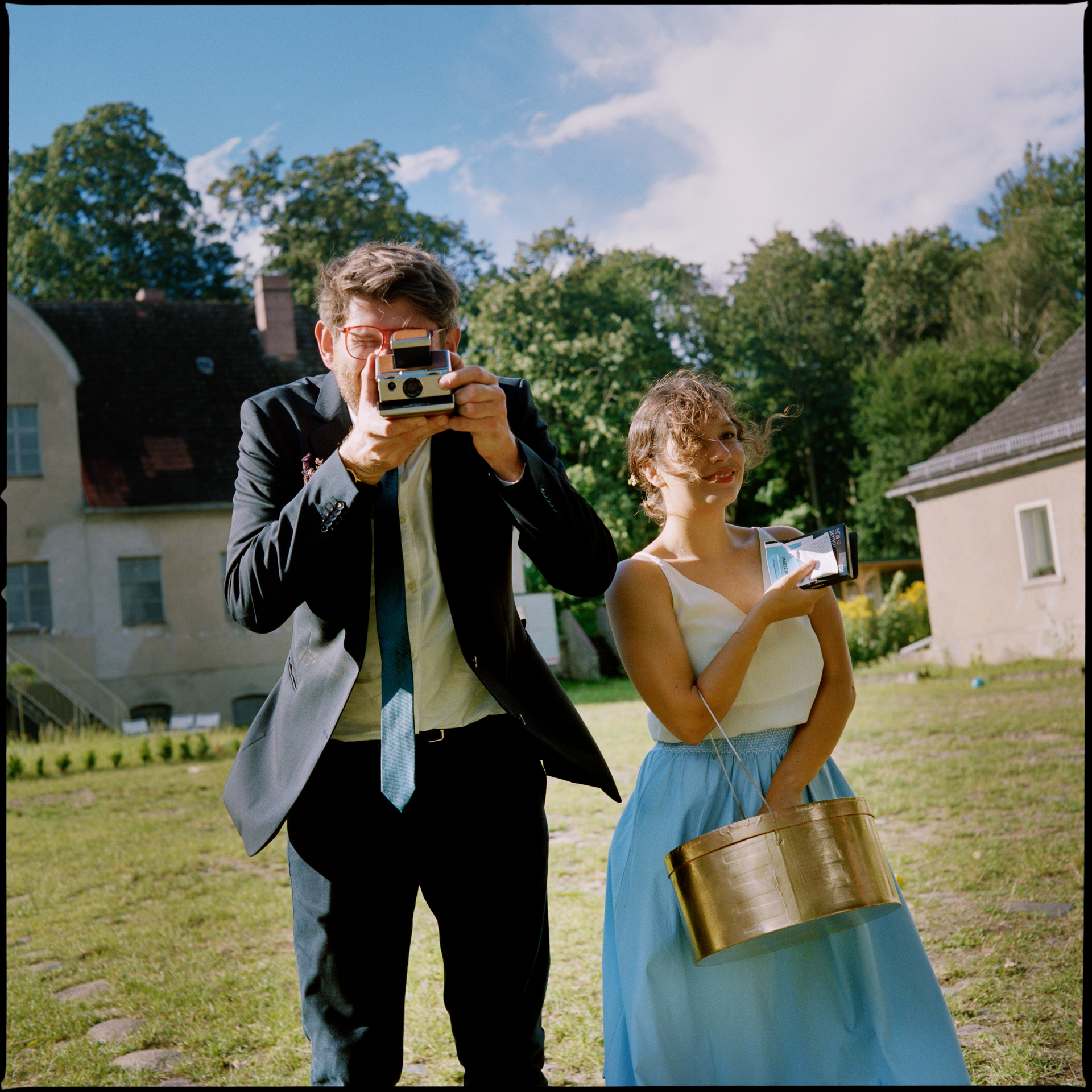 The groom with a camera, the bride beside him, Maike & Daniel wedding in Brandenburg