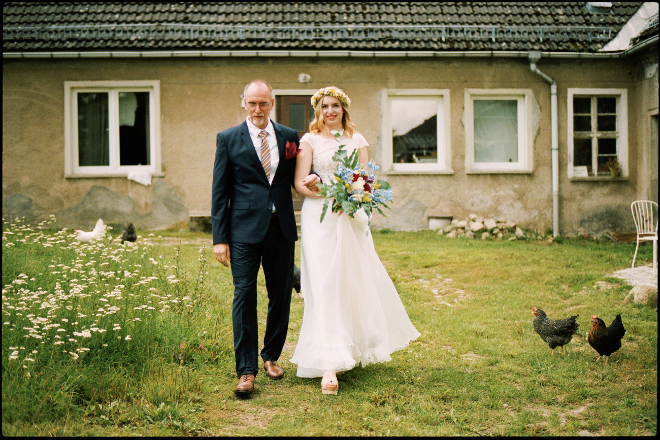 The bride walking with her father across the garden, Maike & Daniel wedding in Brandenburg