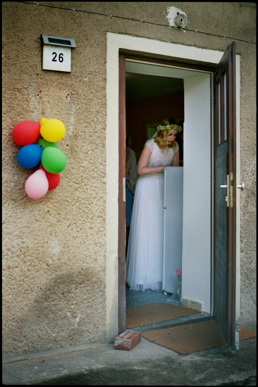 The bride in a doorway, balloons by the entrance, Maike & Daniel wedding in Brandenburg