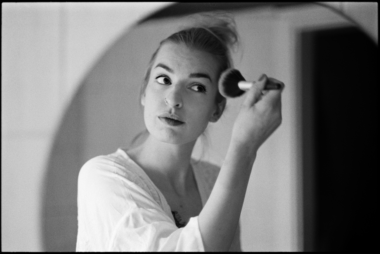 The bride applying her makeup, in black and white, Maike & Daniel wedding in Brandenburg