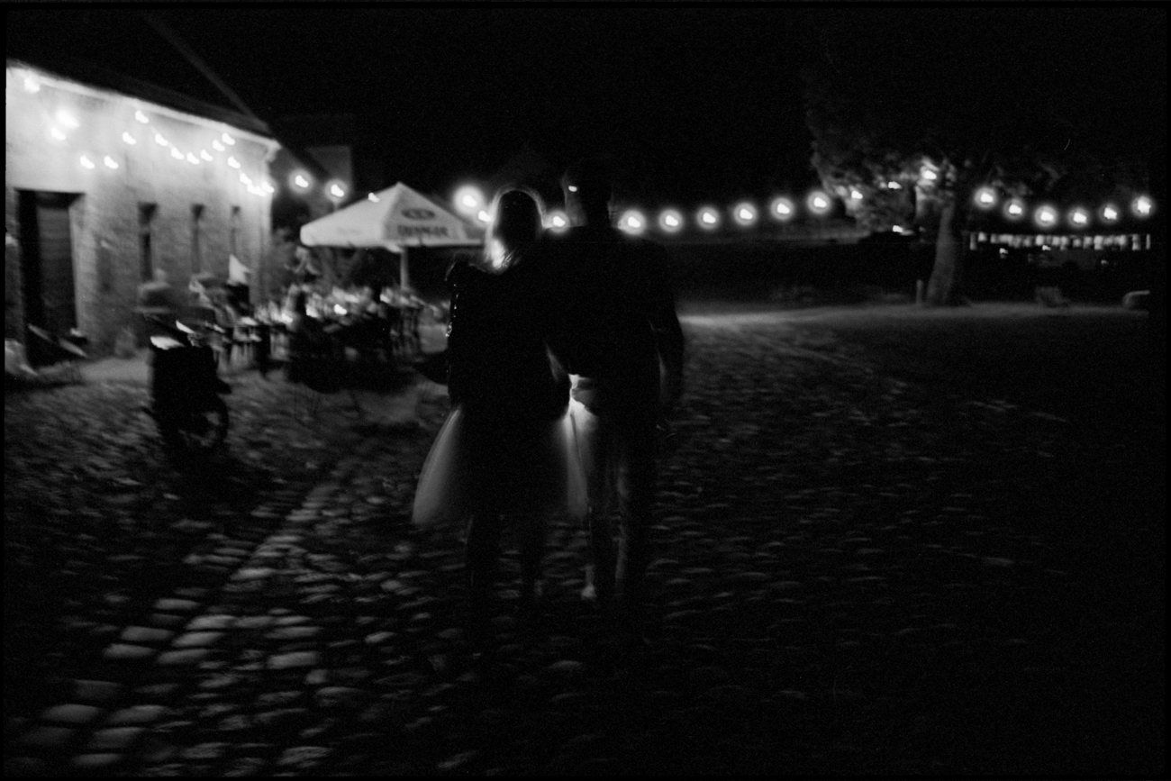The party at night under string lights, in black and white, Maike & Daniel wedding in Brandenburg