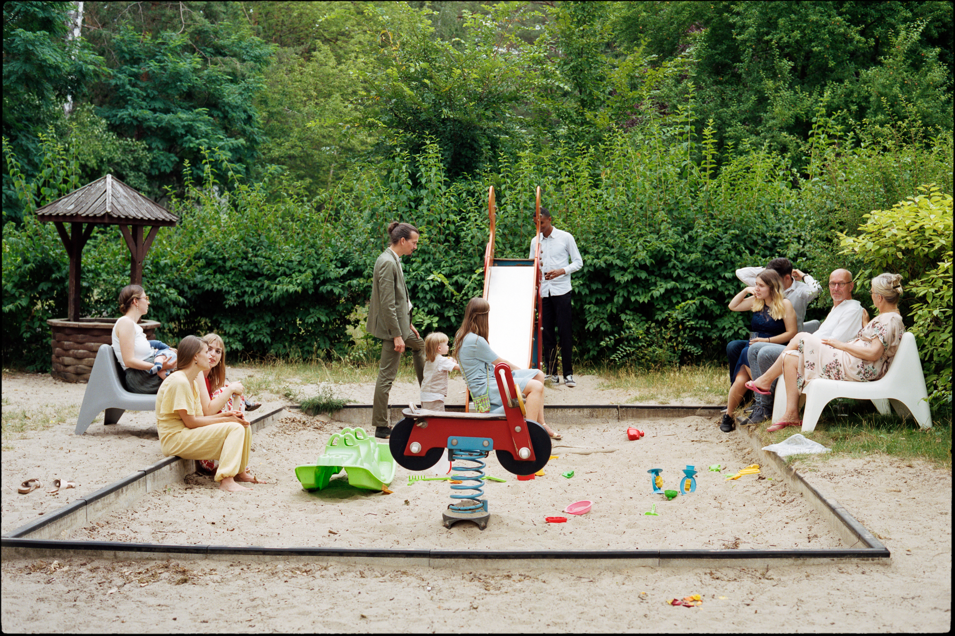 Children playing in a sandpit as guests relax, Suelyn & Pascal wedding in Groß Glienicke, Potsdam