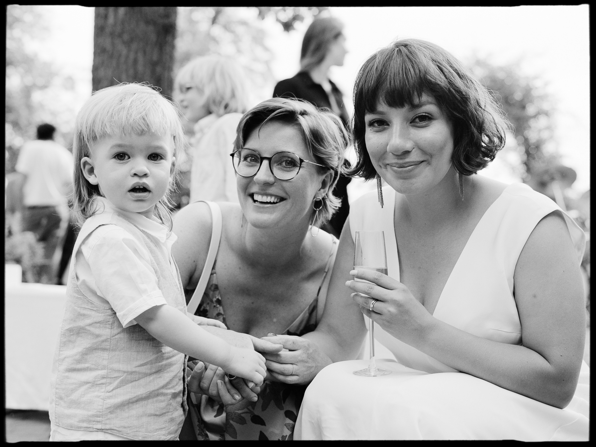 A guest with a child at the celebration, in black and white, Suelyn & Pascal wedding in Groß Glienicke, Potsdam