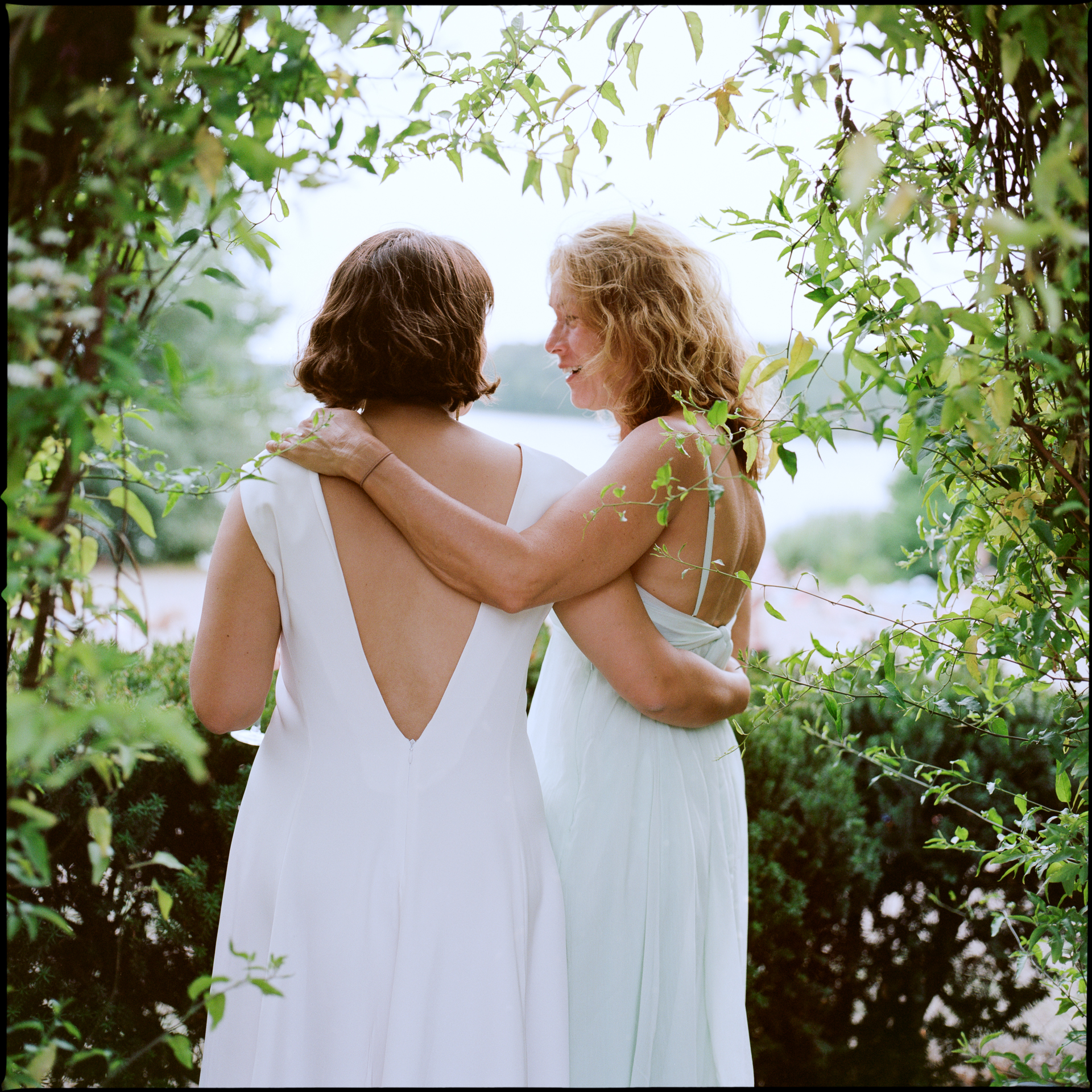 The bride embracing a guest, seen from behind, Suelyn & Pascal wedding in Groß Glienicke, Potsdam