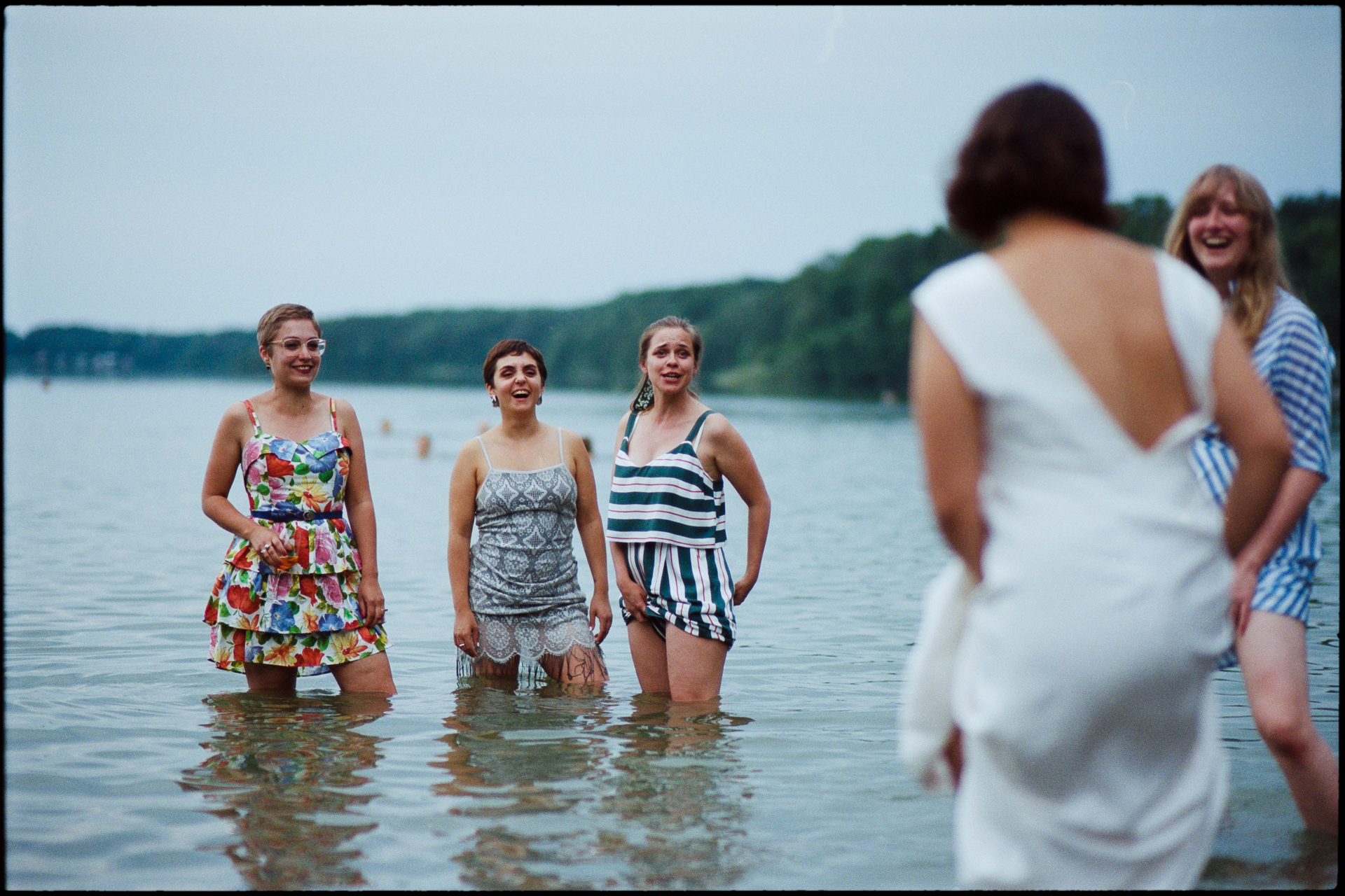 The bride wading into the lake with guests, Suelyn & Pascal wedding in Groß Glienicke, Potsdam
