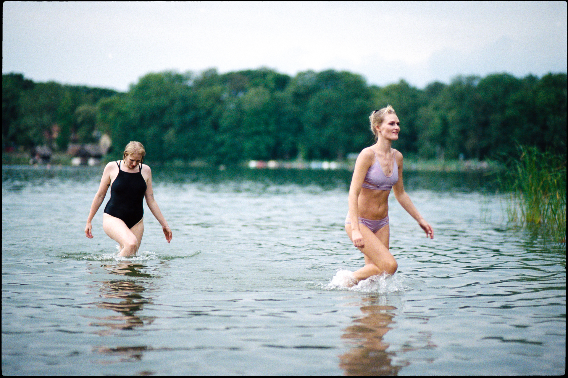 Guests wading in the lake, Suelyn & Pascal wedding in Groß Glienicke, Potsdam