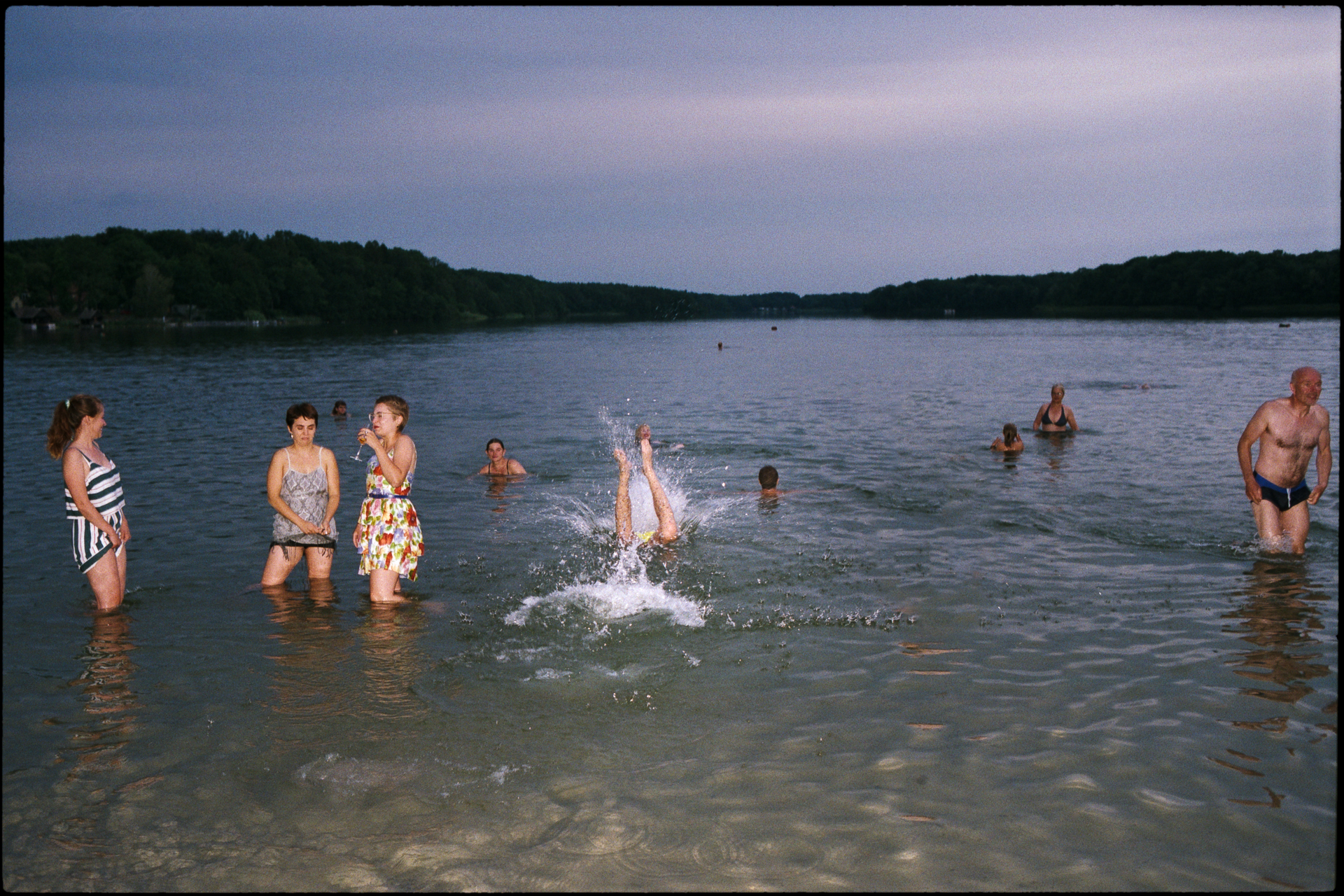 Guests swimming in the lake at dusk, Suelyn & Pascal wedding in Groß Glienicke, Potsdam