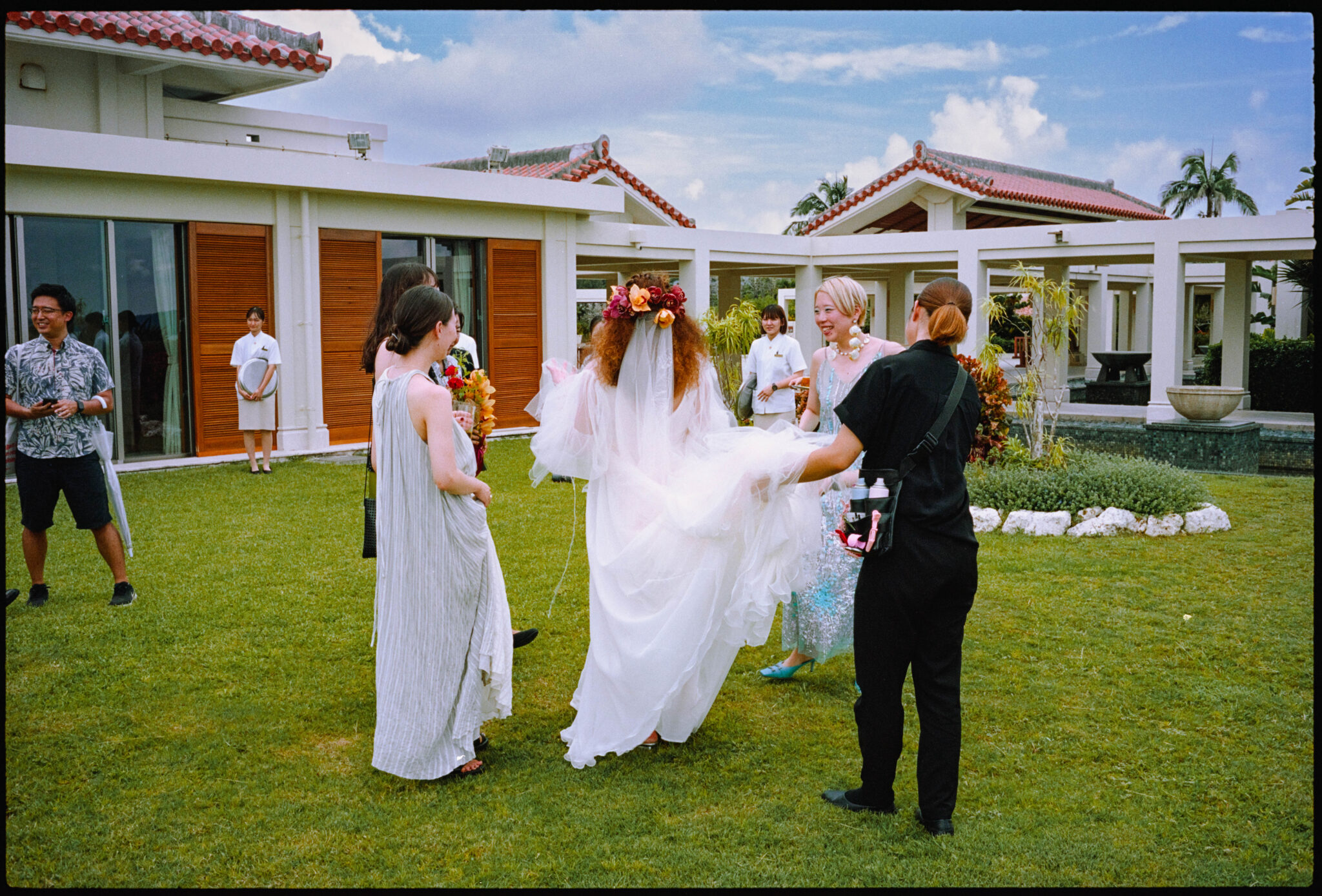 The couple on the lawn with guests, the sea behind, Sugano & Jonas wedding in Okinawa