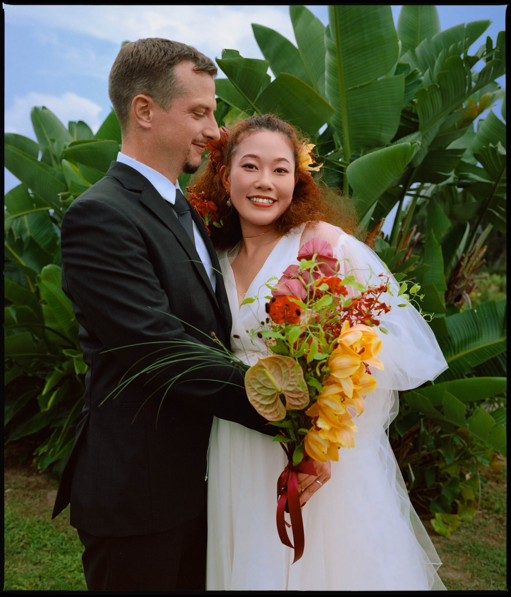 Portrait of the couple among tropical plants, Sugano & Jonas wedding in Okinawa