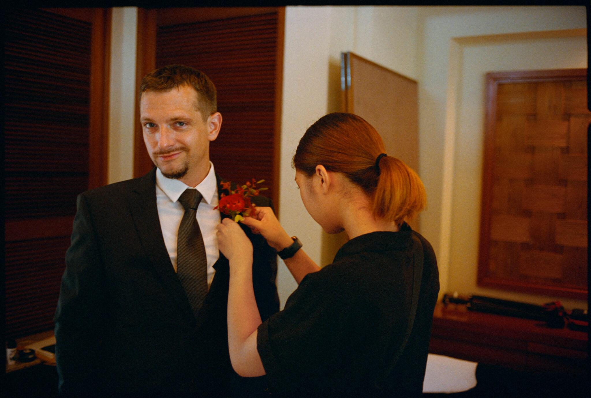 The groom having his boutonnière pinned, Sugano & Jonas wedding in Okinawa