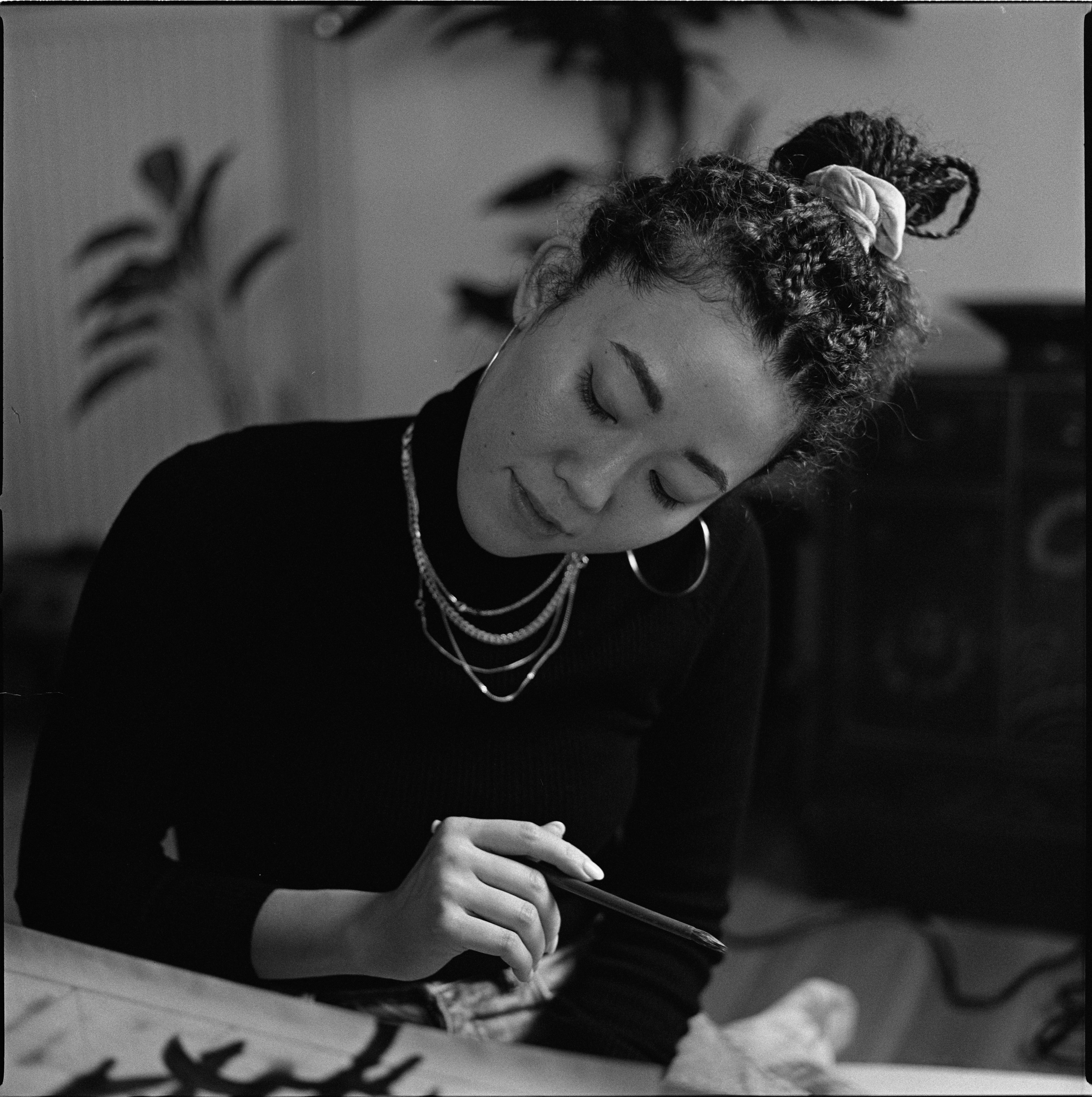 A person bent over their work at a desk, black and white, analogue film portrait by Martina Manz, Berlin