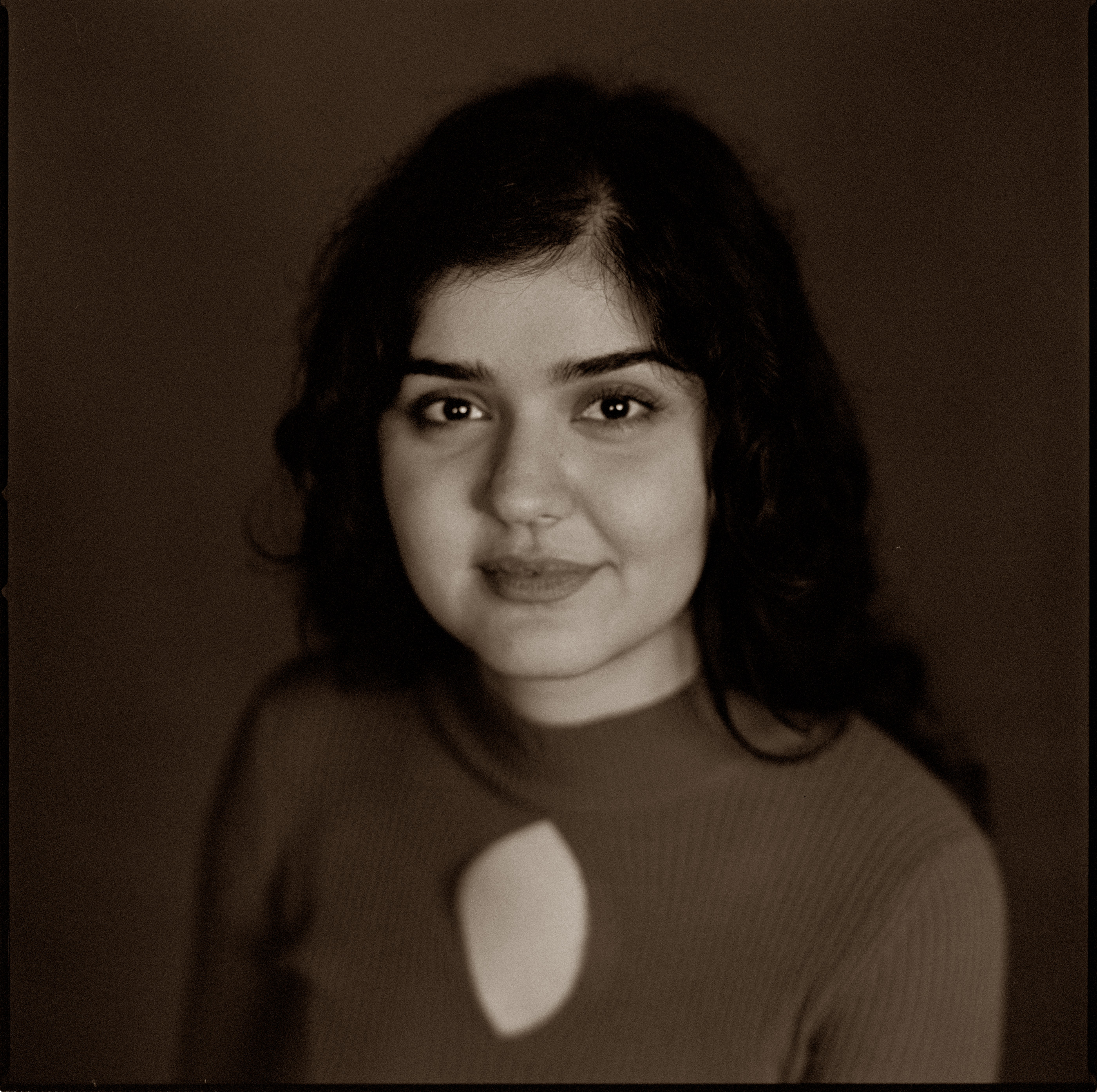 A close portrait of a woman in warm sepia tones, analogue film portrait by Martina Manz, Berlin
